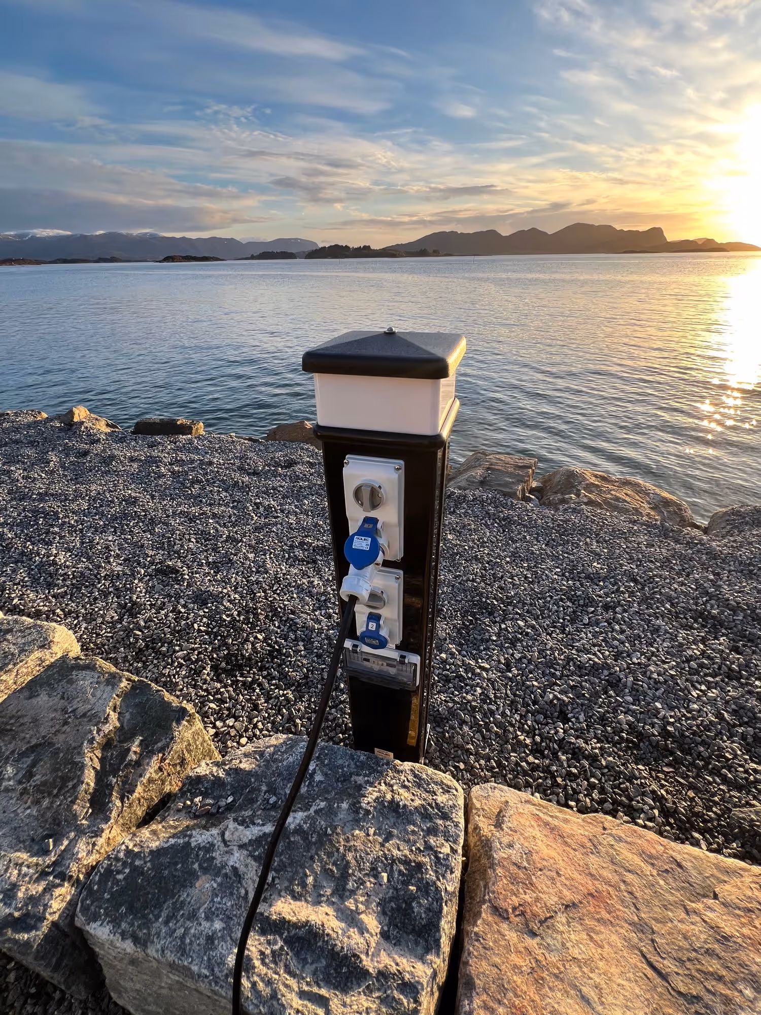 Strømuttak ved en oppstillingsplass i solnedgang
