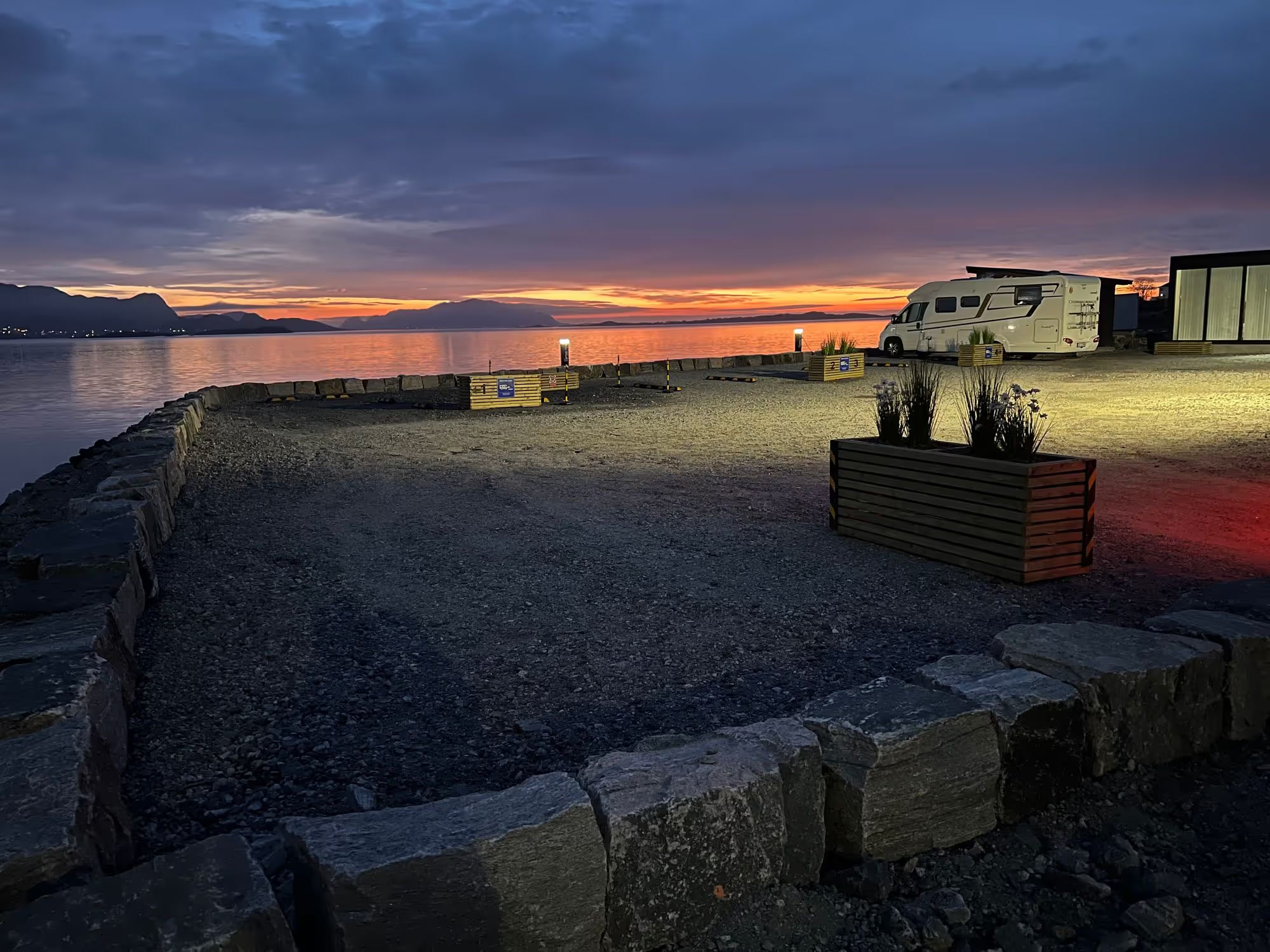 Sjøfronten Bobilpark i solnedgang, med bobil ved havet